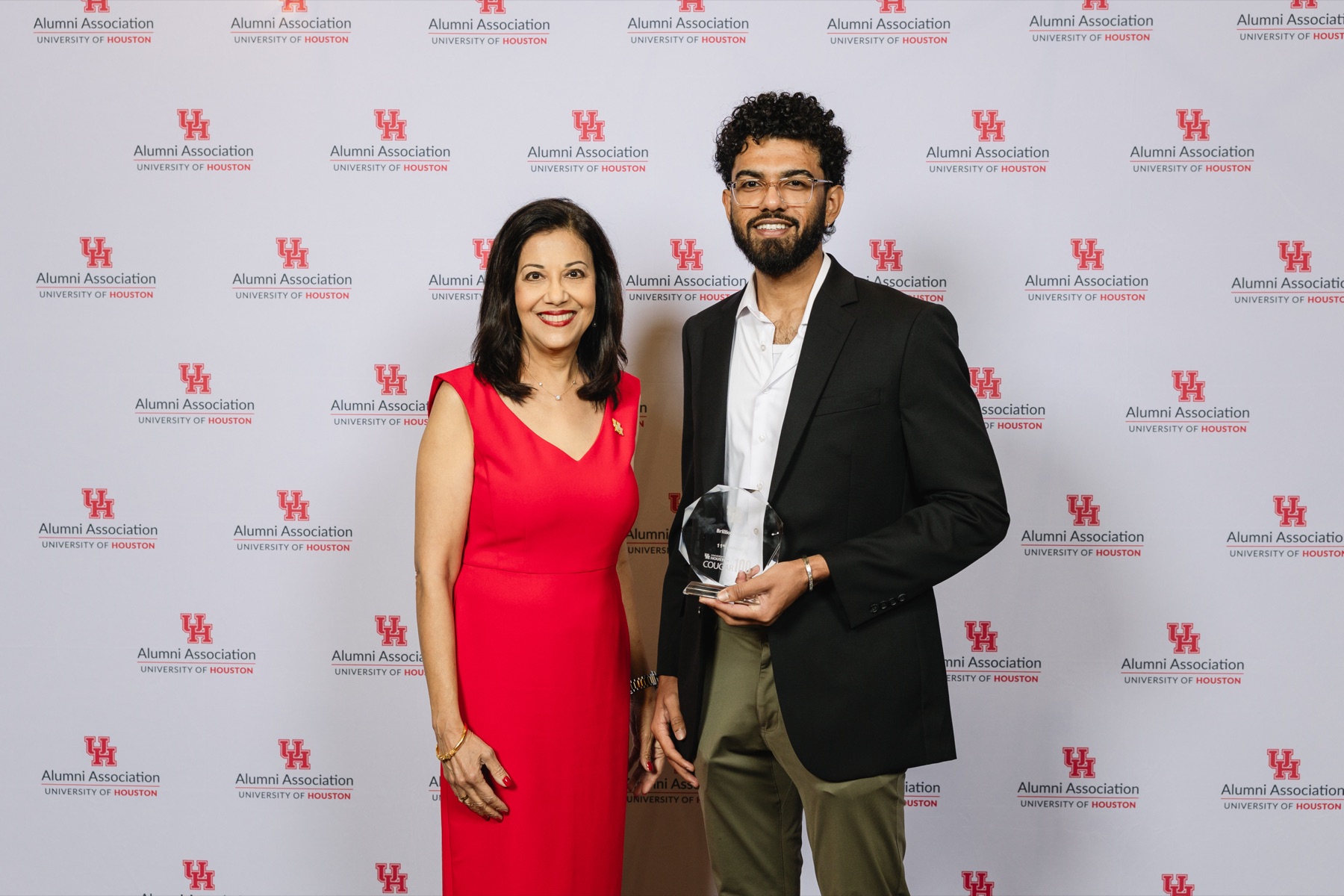 Talha Siddiqui accepting the Cougar 100 crystal award from Dr. Renu Khator at the UH Alumni Association luncheon