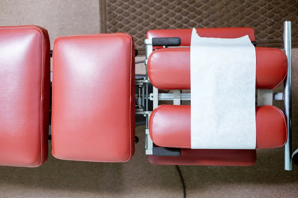 A red chiropractic adjusting table seen from above