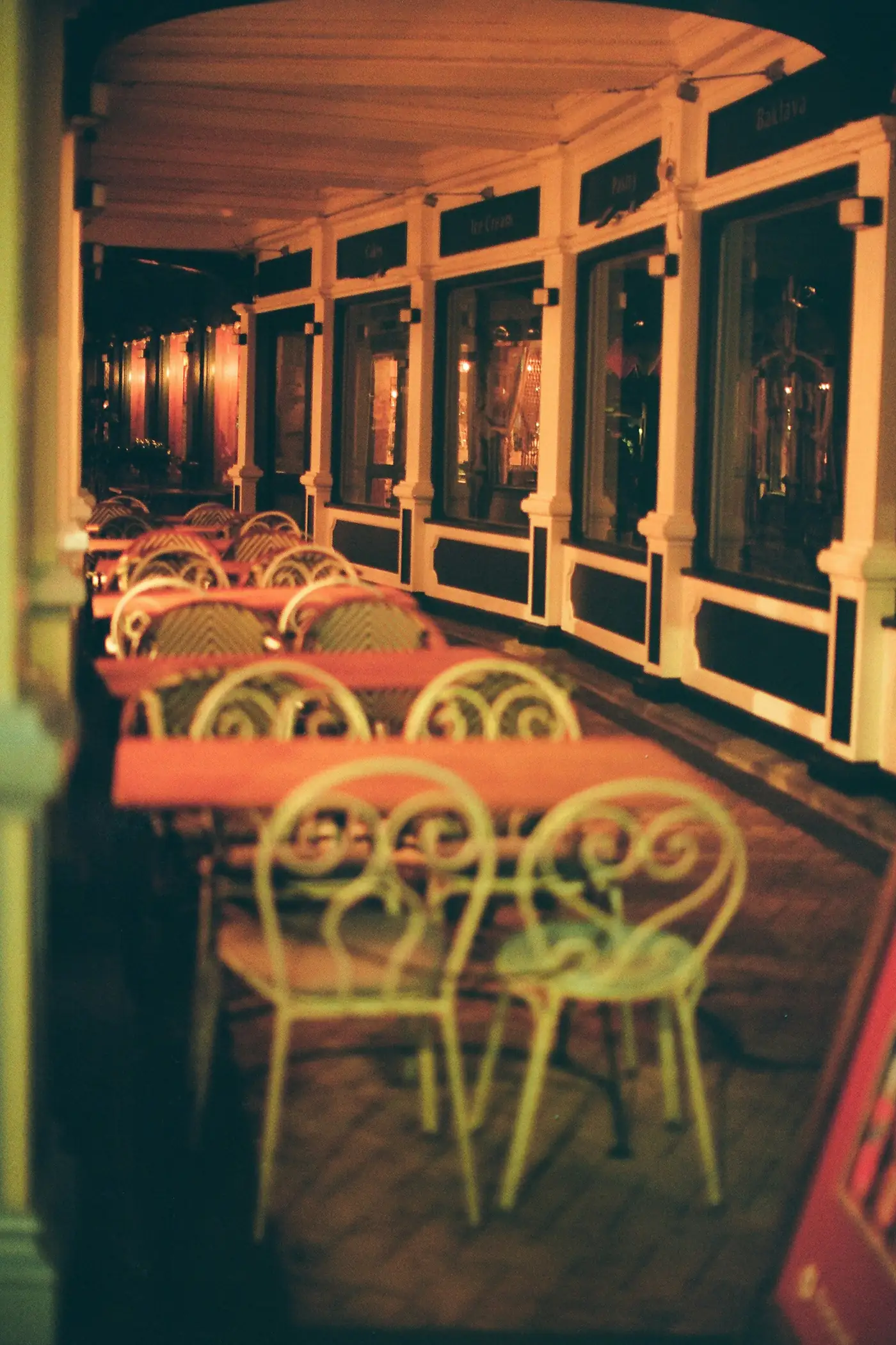 Rows of empty café tables under warm lights at dusk
