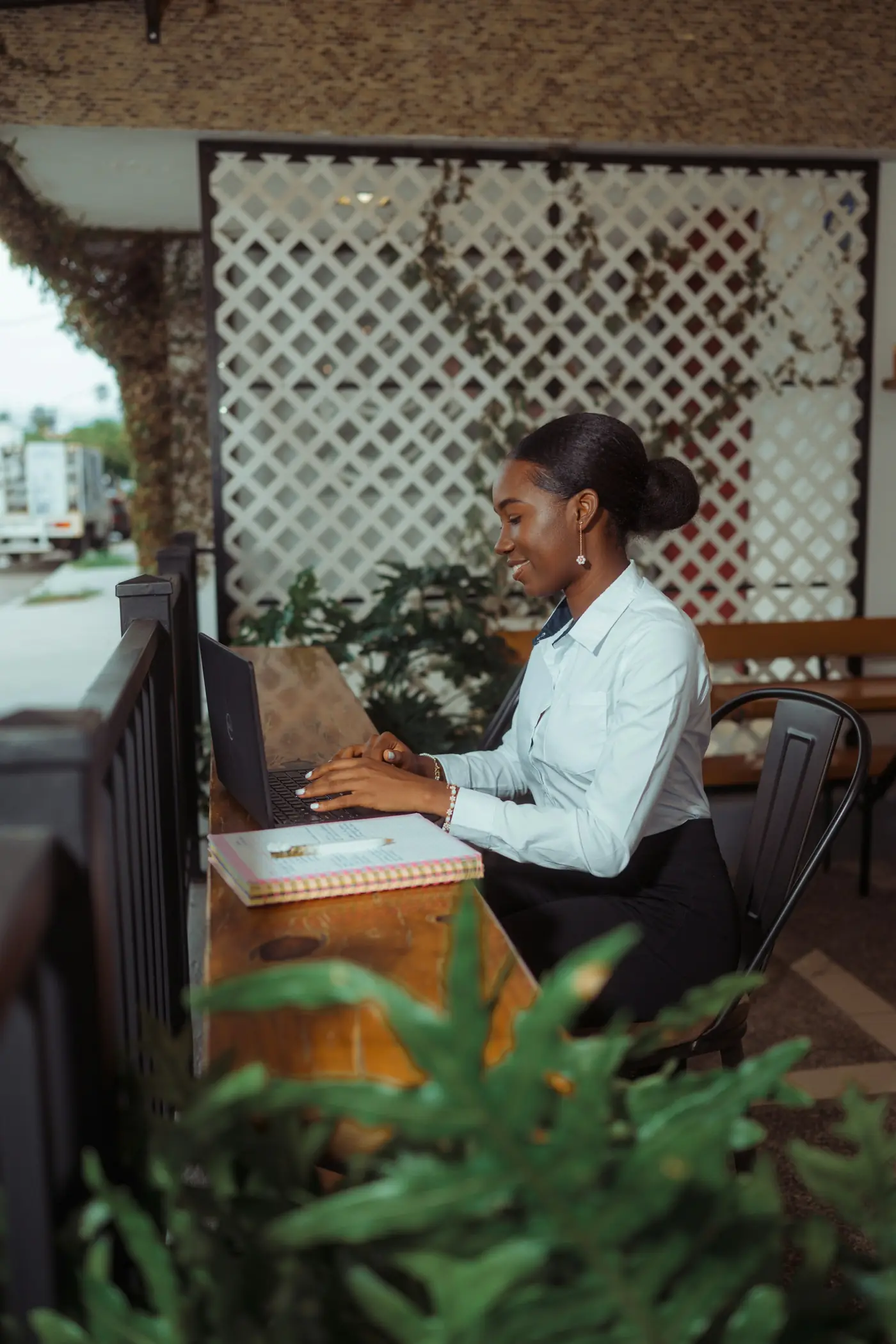 An accountant working at a laptop on a shaded terrace