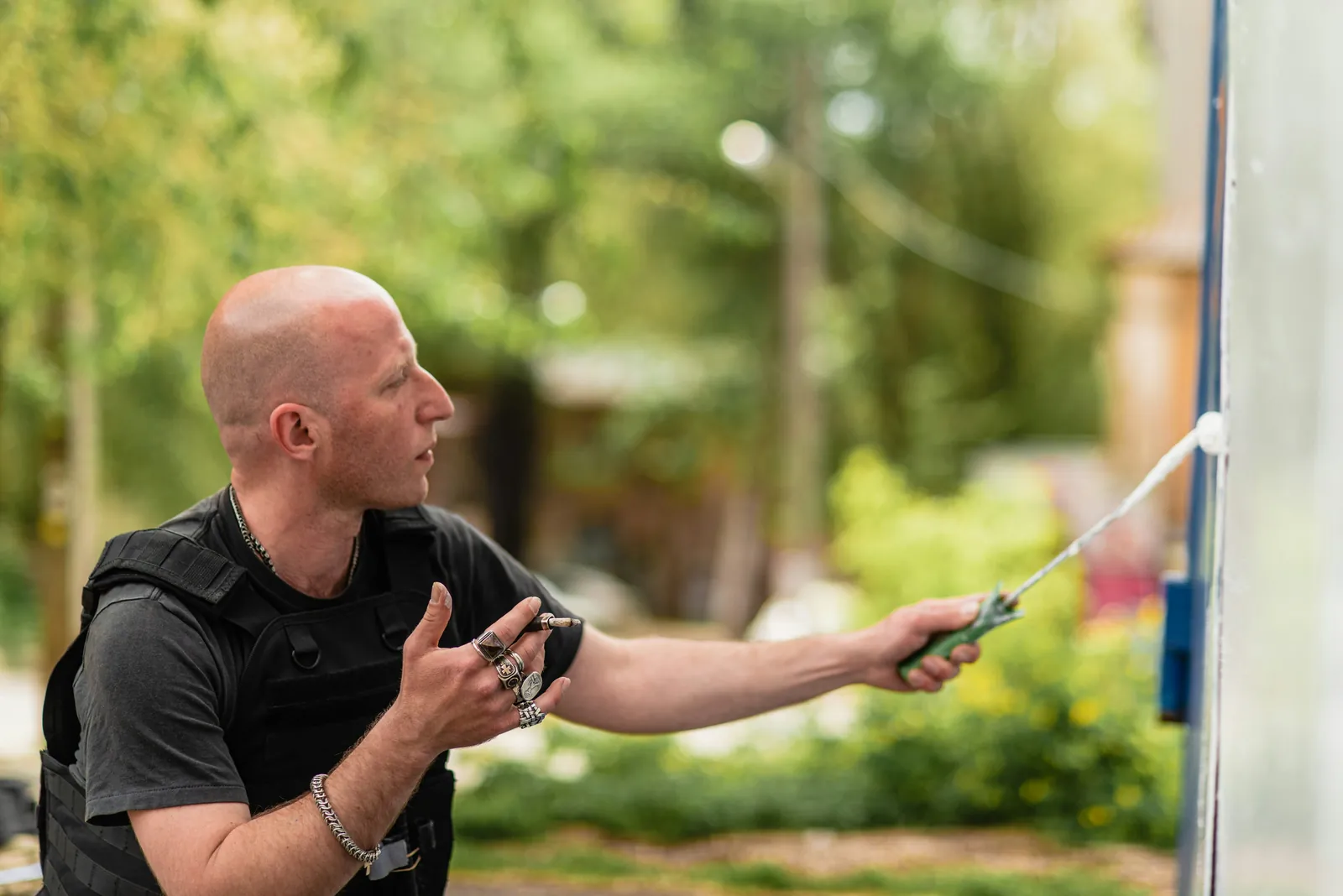 A pest control technician treating along the side of a house