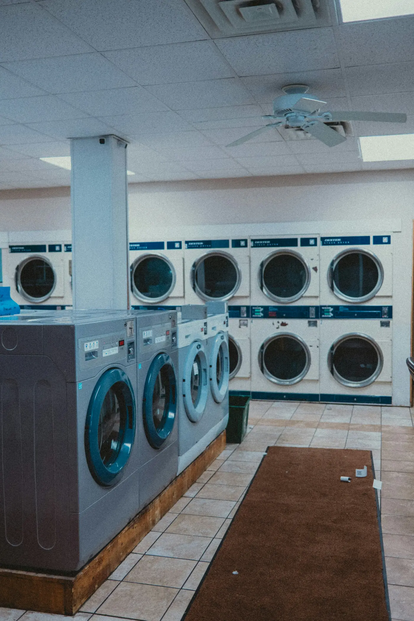 A bright laundromat with rows of front-loading washers