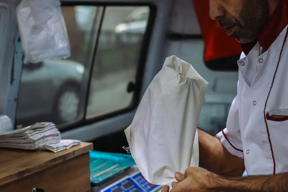 A driver sorting a bag of laundry in the back of a van
