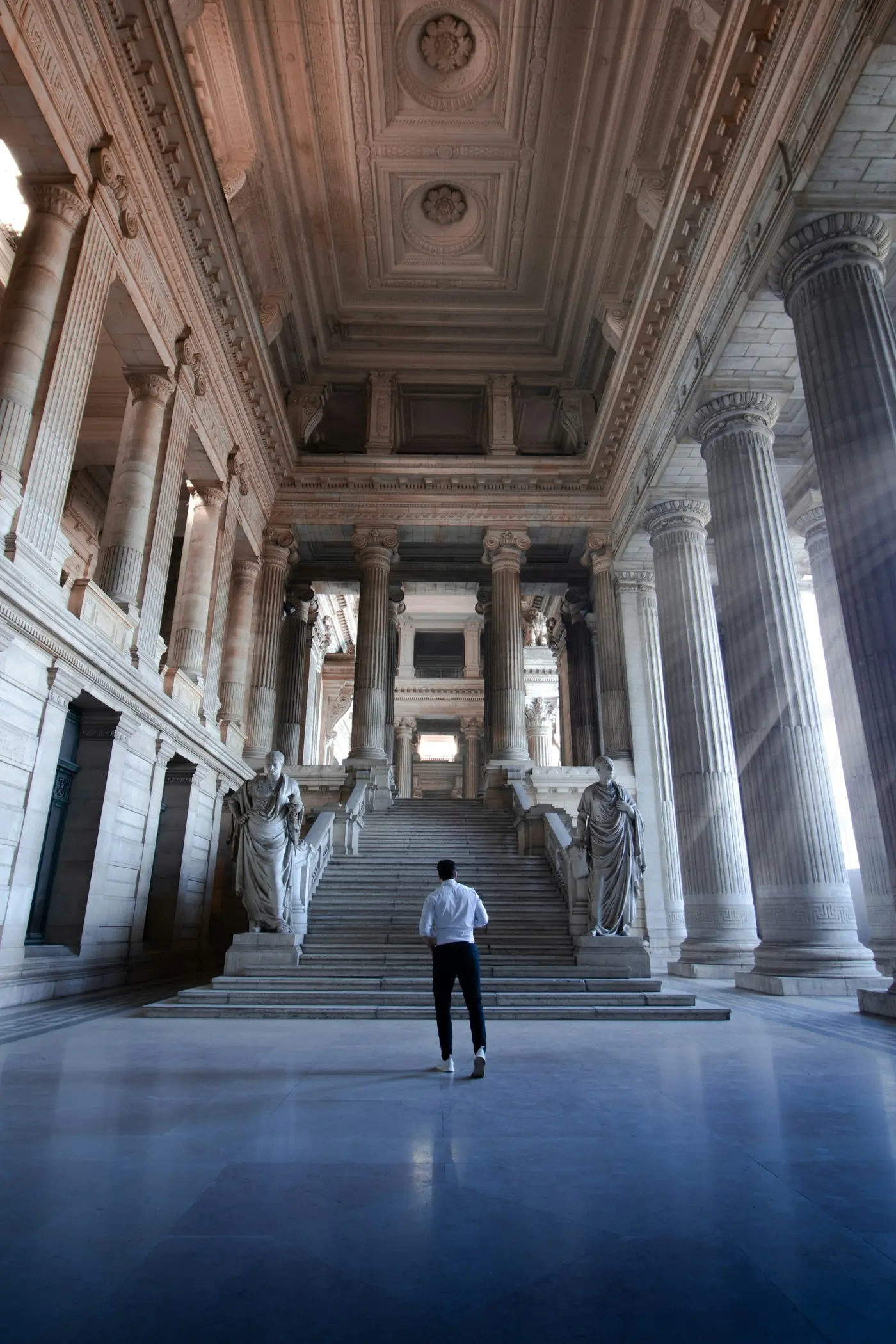 A person walking through a columned courthouse hall