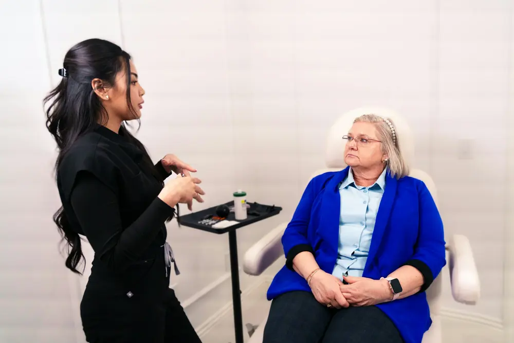 A provider talking with a seated client in a bright consult room