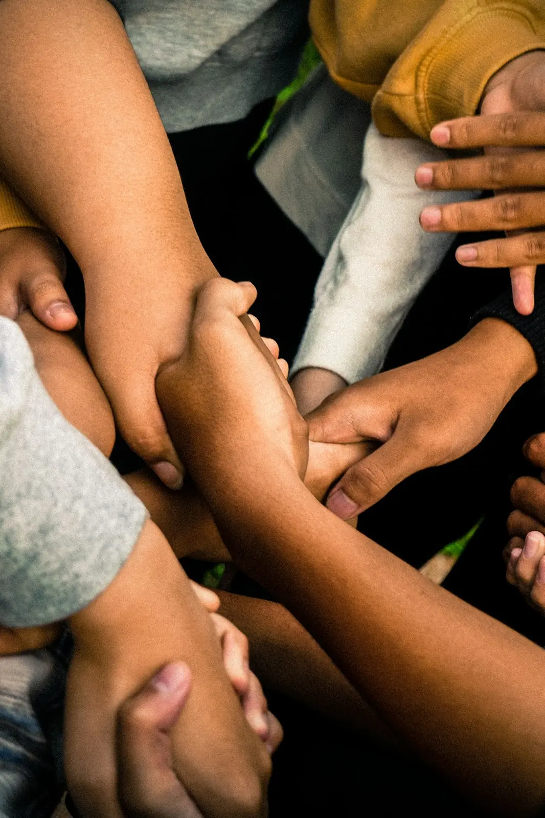 Several hands clasped together