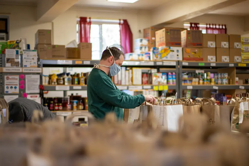 A volunteer stocking the shelves of a food pantry