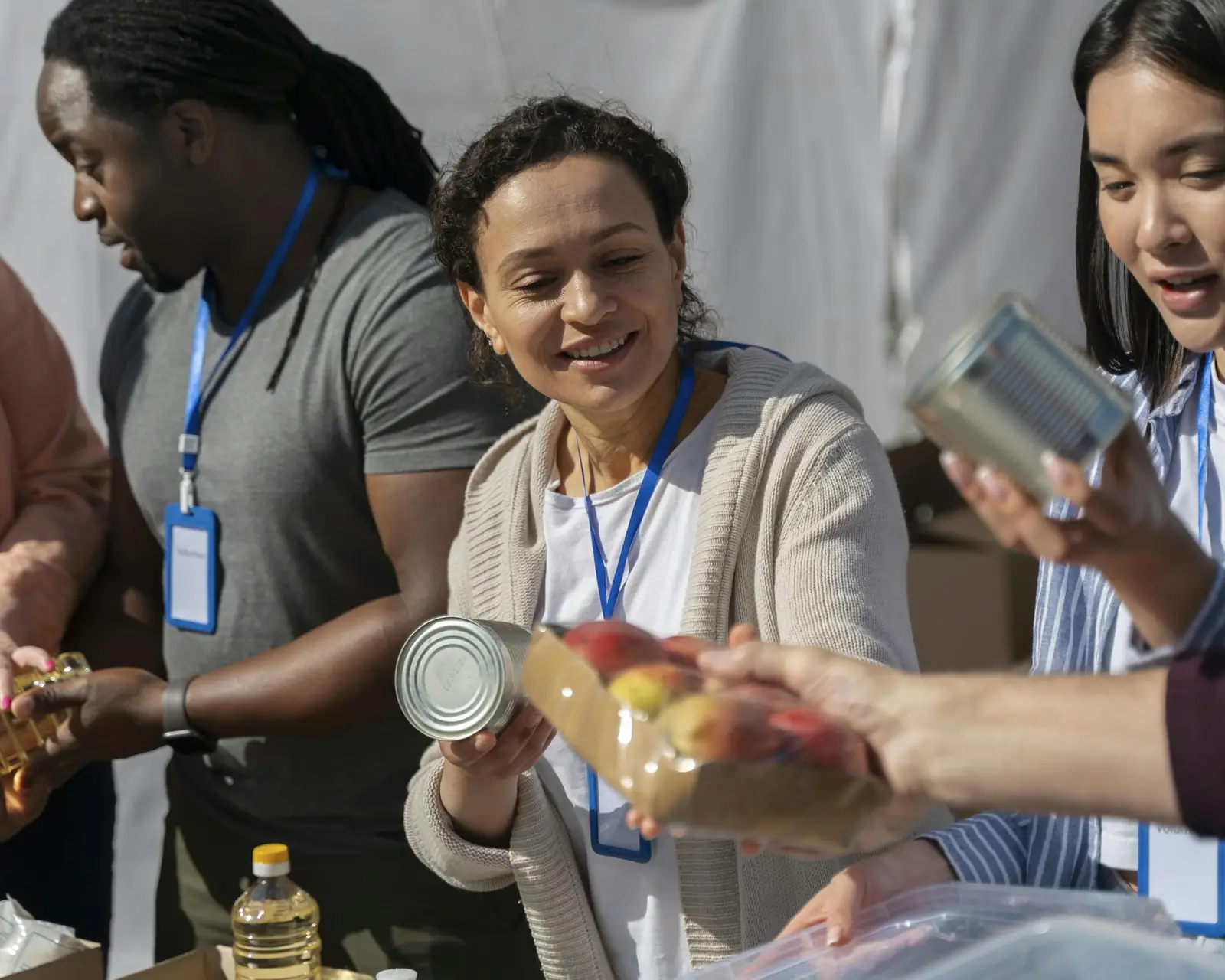 Volunteers smiling as they hand out supplies