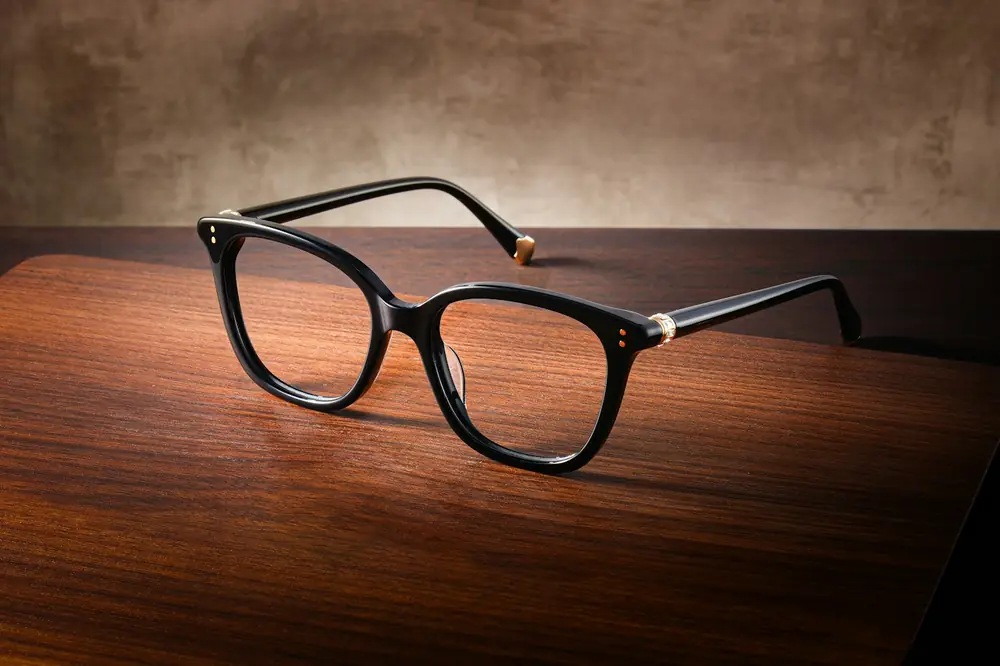 A pair of black glasses on a wooden table