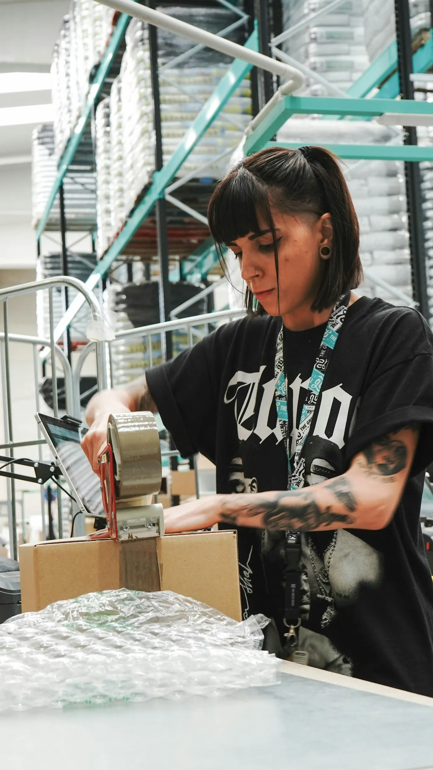 A packer taping up an order in a fulfilment warehouse