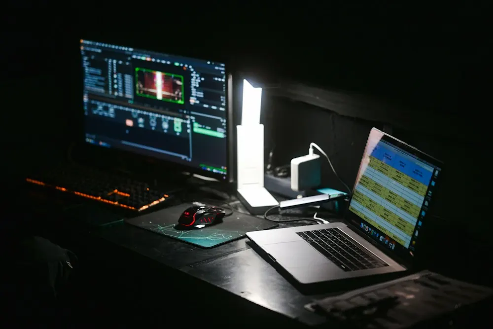 A cluttered desk lit by monitors late at night