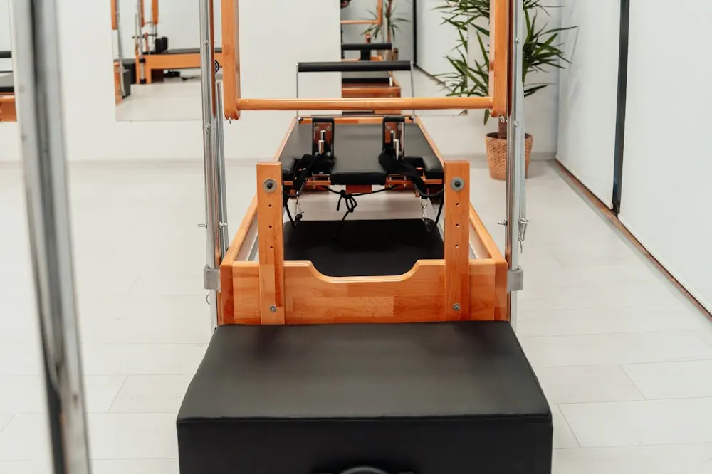An empty reformer under a wooden tower frame in a bright studio