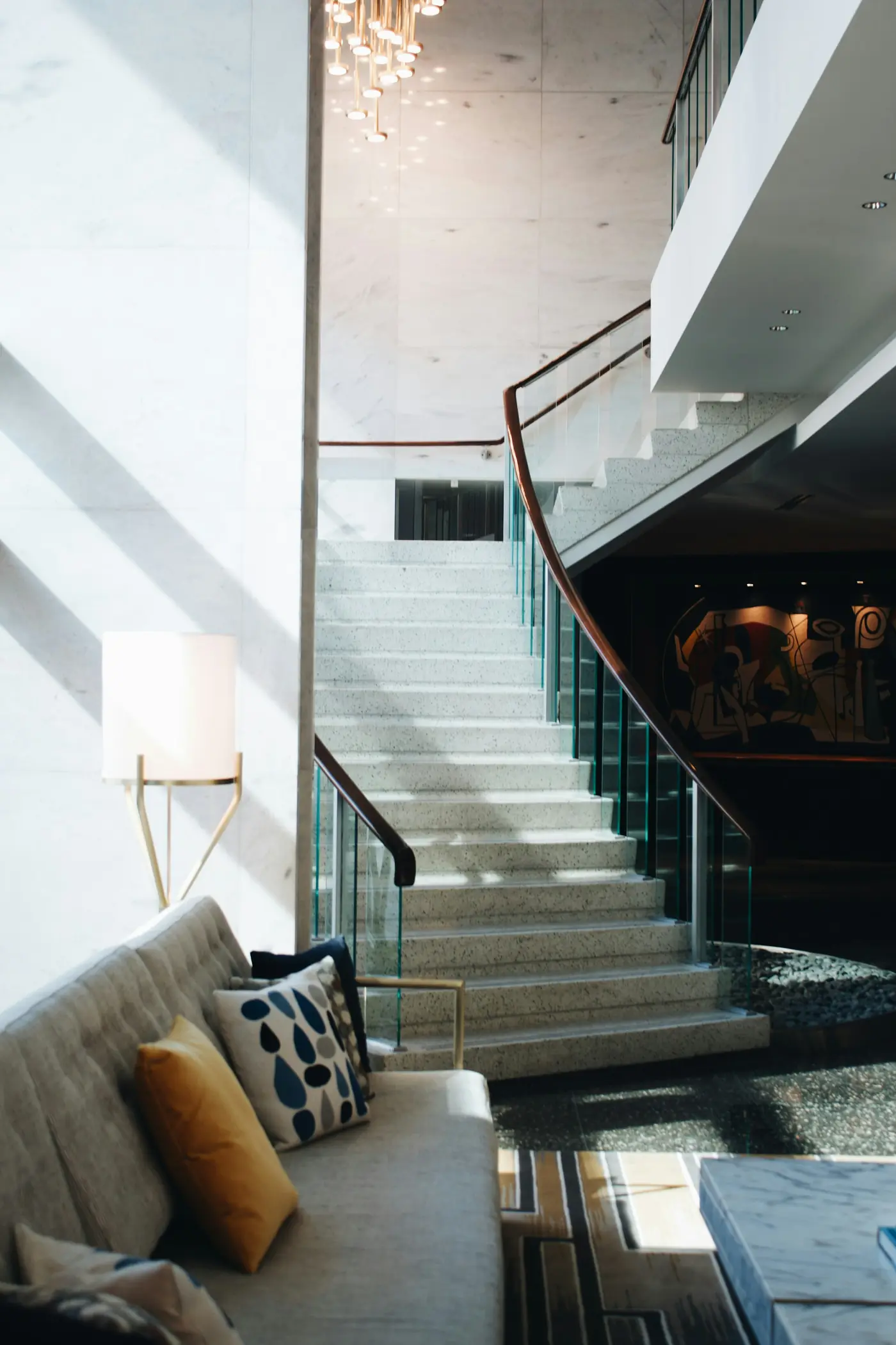 A glass staircase rising through a bright new home