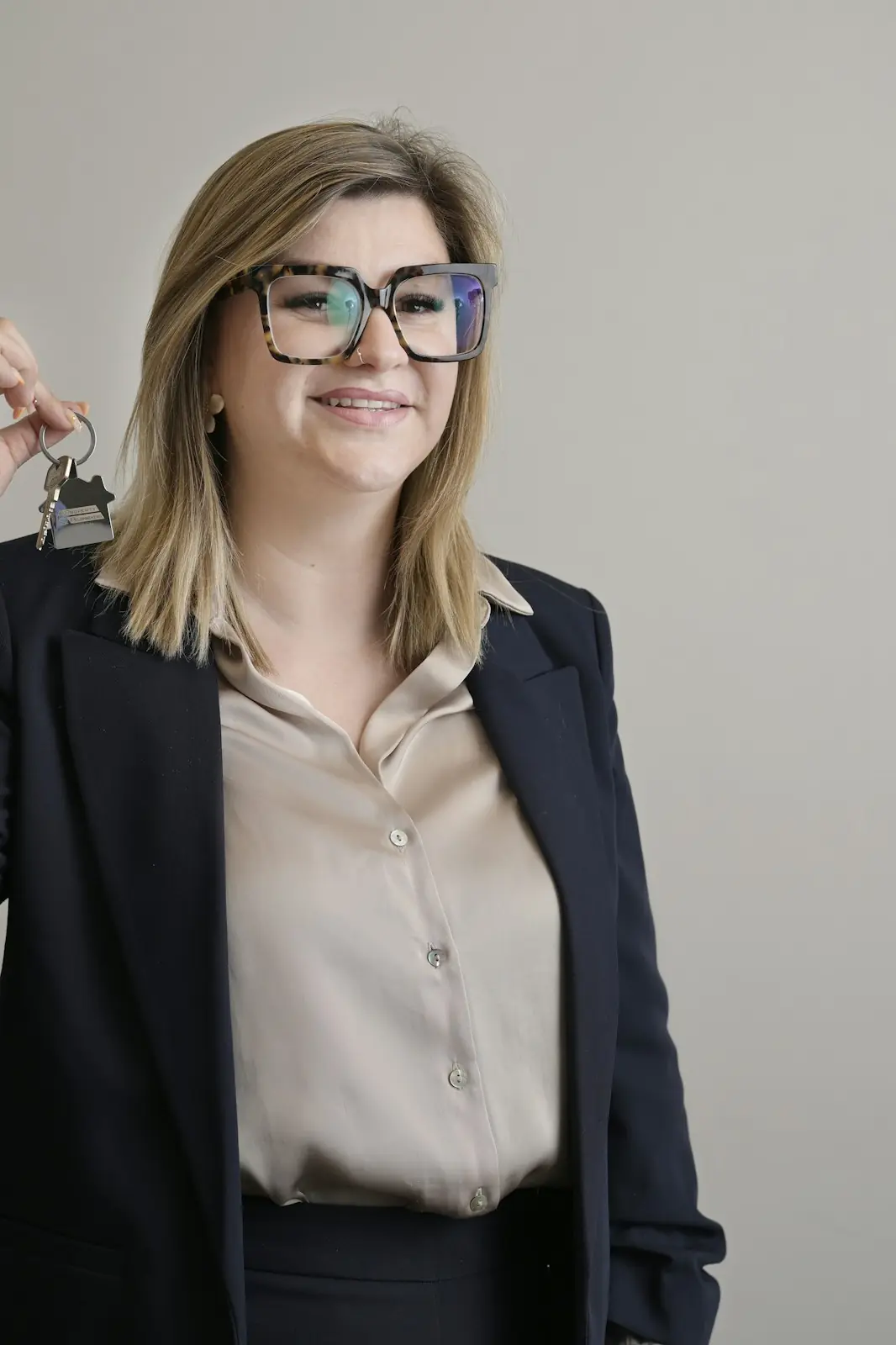 An agent in a blazer holding up a set of house keys