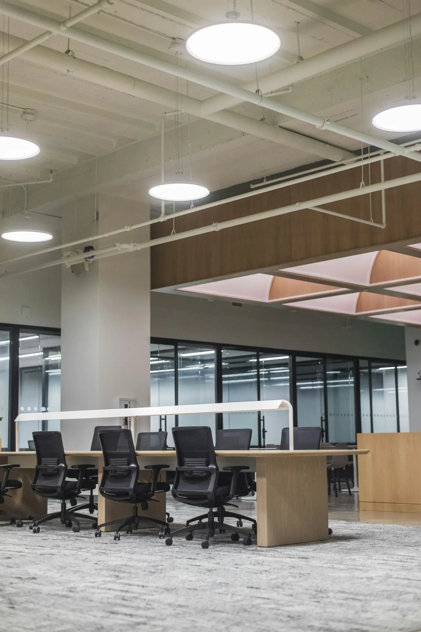 A bright open office with a long meeting table and empty chairs