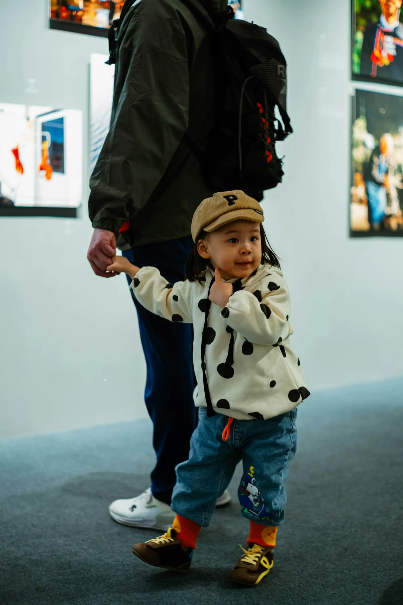 A small child walking hand in hand with a parent
