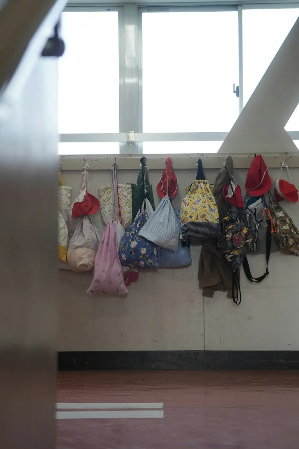 Bags and hats hanging on classroom hooks