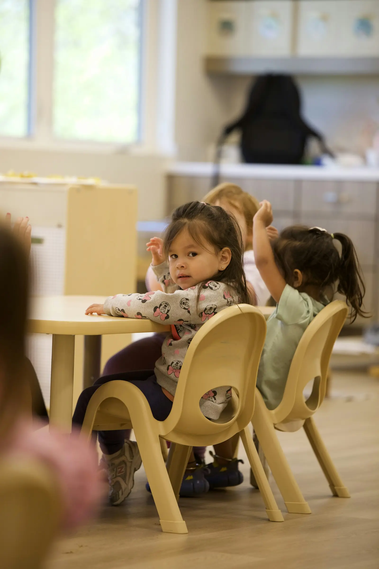 Young children at a table in a bright classroom