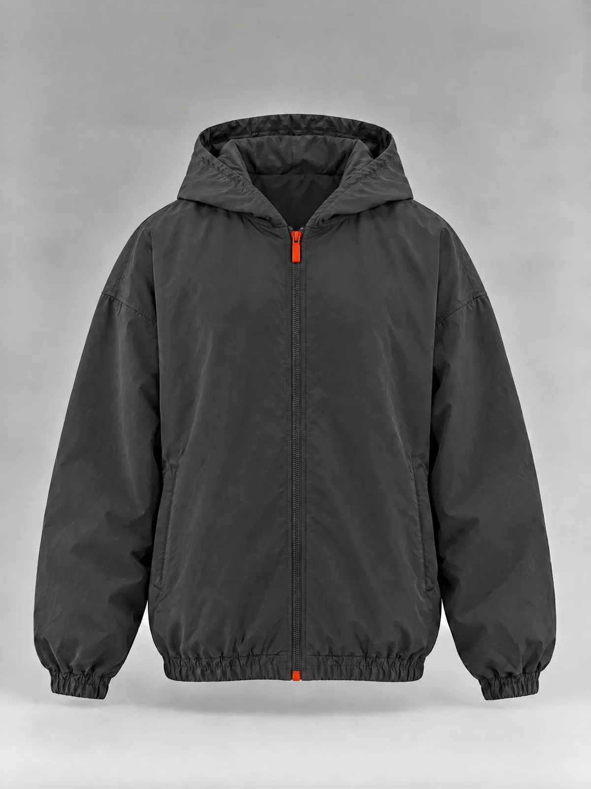 The front of the dark grey nylon zip-up hoodie: a full-length zip with an orange pull, two side pockets, elastic cuffs and hem, and no drawstrings