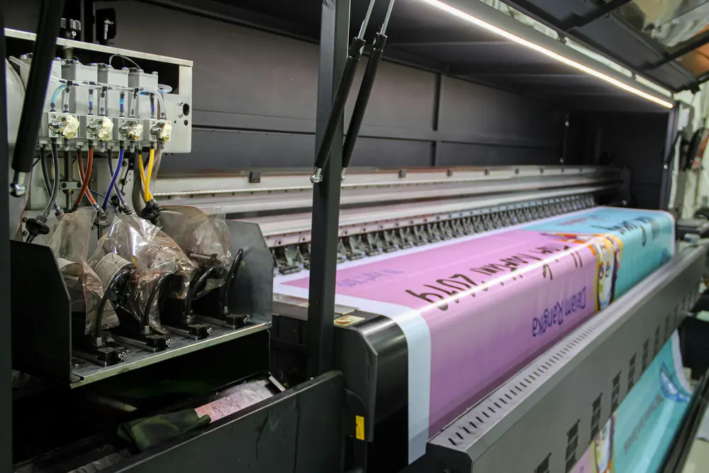 A wide-format printer running a long printed banner
