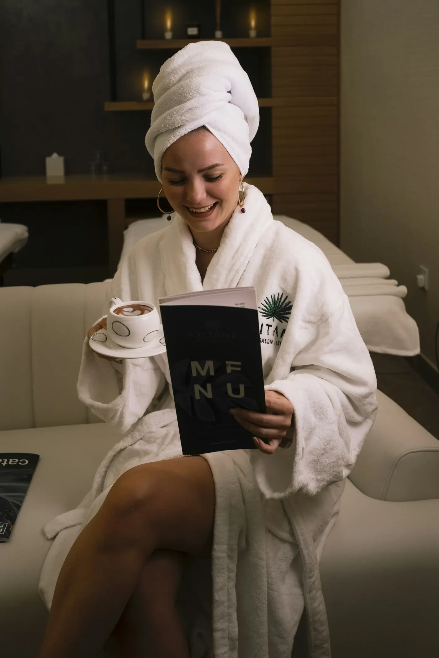 A guest in a white robe reading the spa menu