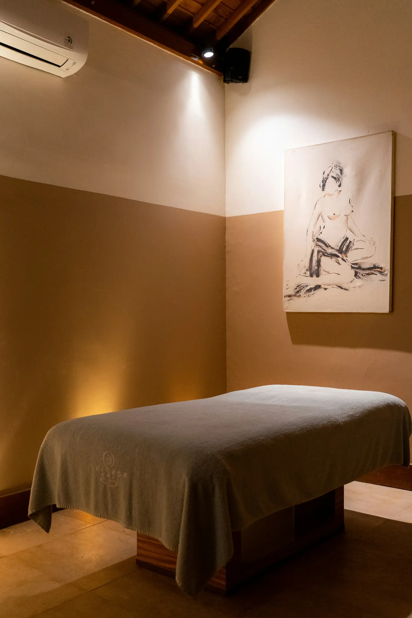 A quiet treatment room with a made-up table and warm light