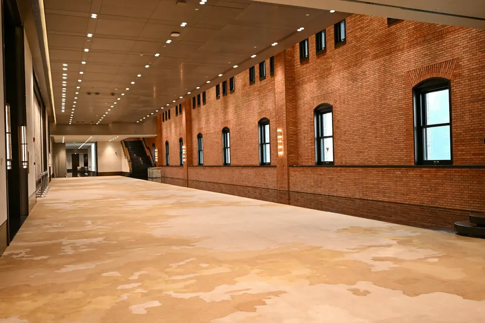An empty hall with brick walls and patterned carpet